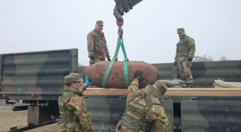 foto militari artificieri che caricano bomba d'aereo inesplosa sul camion