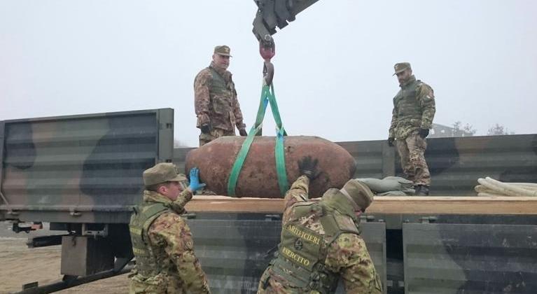 foto militari artificieri che caricano bomba d'aereo inesplosa sul camion